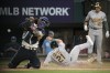 Oakland Athletics' Conner Capel (21) scores ahead of the throw to Texas Rangers catcher Jonah Heim, left, as Ryan Noda (49) looks on in the sixth inning of a baseball game, Friday, April 21, 2023, in Arlington, Texas. Capel scored on a Esteury Ruiz single. (AP Photo/Tony Gutierrez)