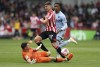 Aston Villa goalkeeper Emiliano Martinez, left, saves at the feet of Brentford's Vitaly Janelt centre, during the English Premier League soccer match between Brentford and Aston Villa at the Gtech Community Stadium, in London, Saturday April 22, 2023. (Kieran Cleeves/PA via AP)