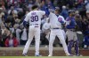 Chicago Cubs' Nico Hoerner, right, high-fives Chicago Cubs' Edwin Rios after hitting a two-run home run during the seventh inning of a baseball game against the Los Angeles Dodgers Saturday, April 22, 2023, in Chicago. (AP Photo/Erin Hooley)