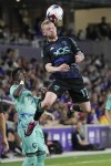 D.C. United's Lewis O'Brien (17) heads the ball above Orlando City's Ivan Angulo during the second half of an MLS soccer match Saturday, April 22, 2023, in Orlando, Fla. (AP Photo/John Raoux)