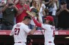 Los Angeles Angels center fielder Brett Phillips (8) puts a kabuto on the head of Mike Trout (27) after Trout hit a home run during the fifth inning of a baseball game against the Kansas City Royals in Anaheim, Calif., Saturday, April 22, 2023. Luis Rengifo also scored. (AP Photo/Ashley Landis)