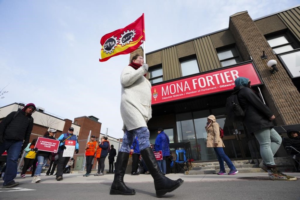 PSAC workers and supporters picket in front of President of the Treasury Board Mona Fortier's office in Ottawa on Friday, April 21, 2023. One of Canada's largest labour disruptions has entered a sixth day, as the union representing thousands of striking public-service workers looks to delay access to ports. THE CANADIAN PRESS/Sean Kilpatrick