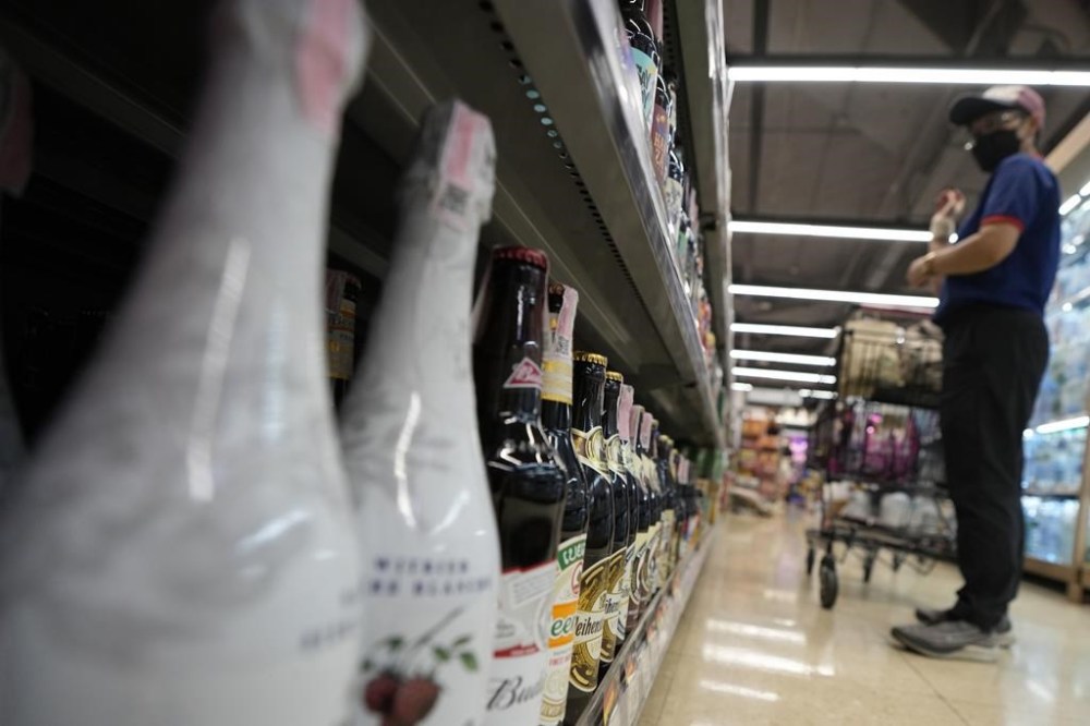A customer looks at beer on shelves at a supermarket in Bangkok, Thailand, Monday, April 24, 2023. Thai beer enthusiast Artid Sivahansaphan said Monday he has been handed a 150,000 baht ($4,360) fine and a suspended six-month prison sentence for violating a law on advertising alcoholic beverages by posting a photo of an IPA-style beer with his evaluation of it on Facebook. (AP Photo/Sakchai Lalit)