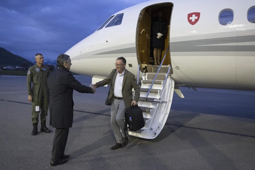 Swiss Federal Councilor Ignazio Cassis, left, welcomes Christian Winter, Swiss Ambassador to Sudan, at the Bern-Belp Airport in Belp, Switzerland, Tuesday, April 25, 2023. Swiss nationals are flown out of the crisis area in Sudan. (Peter Schneider/Keystone via AP, Pool)