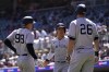 New York Yankees' Aaron Judge (99) and Anthony Volpe, middle, celebrate next to DJ LeMahieu (26) after scoring off a two-run double by Anthony Rizzo during the fourth inning of a baseball game against the Minnesota Twins, Wednesday, April 26, 2023, in Minneapolis. (AP Photo/Abbie Parr)
