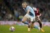 Arsenal's Thomas Partey, right, tries to hold back Manchester City's Erling Haaland during the English Premier League soccer match between Manchester City and Arsenal at Etihad stadium in Manchester, England, Wednesday, April 26, 2023. (AP Photo/Dave Thompson)