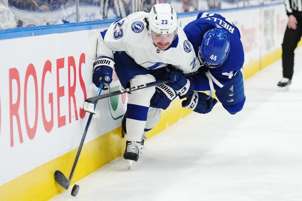Tampa Bay Lightning forward Michael Eyssimont (23) and Toronto Maple Leafs defenceman Morgan Rielly (44) battle for the puck during third period NHL Stanley Cup playoff hockey action in Toronto on Thursday, April 27, 2023. THE CANADIAN PRESS/Nathan Denette