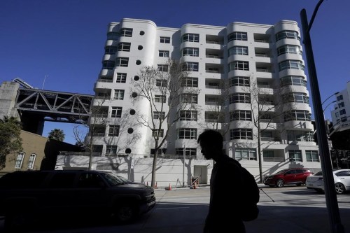 A pedestrian walks across the street from the building, Wednesday, April 12, 2023, in San Francisco, where a technology executive was fatally stabbed outside. The tech entrepreneurs who flocked to San Francisco two decades ago bringing jobs and wealth, and also soaring housing prices and gentrification, are becoming a rising political force in a city they say is woefully off track. (AP Photo/Jeff Chiu)