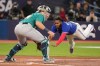 Toronto Blue Jays' Vladimir Guerrero Jr. slides safely home in front of Seattle Mariners catcher Cal Raleigh on an RBI double off the bat of Matt Chapman during third inning American League MLB baseball action in Toronto on Friday, April 28, 2023. THE CANADIAN PRESS/Chris Young