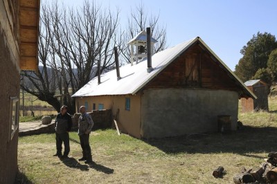 Fidel Trujillo, left, and Leo Paul Pacheco, look at the kitchen recently built with adobe next to the 1860s morada de San Isidro, which is the main chapel and meeting point of their Catholic brotherhood, outside Holman, New Mexico, Saturday, April 15, 2023. The morada is used for prayer, study and hosting pilgrims, all traditions for the brotherhood that for centuries have played a crucial role in preserving the faith in these remote mountain valleys. (AP Photo/Giovanna Dell'Orto)