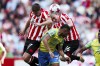 Nottingham Forest's Renan Lodi, center, battles for the ball against Brentford's Vitaly Janelt, left, and Ben Mee during the English Premier League soccer match between Brentford and Nottingham Forest at the Gtech Community Stadium, London, Saturday, April 29, 2023. (Nick Potts/PA via AP)