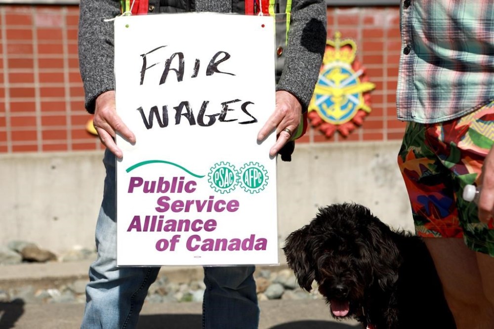 PSAC workers walk the picket line out front of His Majesty's Canadian Dockyard in Esquimalt, B.C., on Friday, April 28, 2023. The federal government says an offer extended Friday to striking federal workers is final and describes it as fair and competitive. THE CANADIAN PRESS/Chad Hipolito