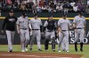 New York Yankees manager Aaron Boone, left, puts his arm around outfielder Jake Bauers as they walk back to the dugout after Bauers collided with the outfield wall while atching a fly ball hit by Texas Rangers' Adolis Garcia during the first inning of a baseball game Saturday, April 29, 2023, in Arlington, Texas. (AP Photo/Sam Hodde)