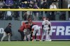 Arizona Diamondbacks left fielder Corbin Carroll is helped up by team personnel in the outfield in the sixth inning of a baseball game against the Colorado Rockies, Saturday, April 29, 2023, in Denver. (AP Photo/Geneva Heffernan)