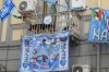 Dogs peers through the fence of a balcony adorned with Napoli soccer team flags, in Naples, Italy, Sunday, April 30, 2023. After Napoli's game was moved to Sunday, the team could secure the title in front of their own fans by beating Salernitana — if Lazio fails to win at Inter Milan earlier in the day. Diego Maradona led Napoli to its only previous Serie A titles in 1987 and 1990. (AP Photo/Gregorio Borgia)