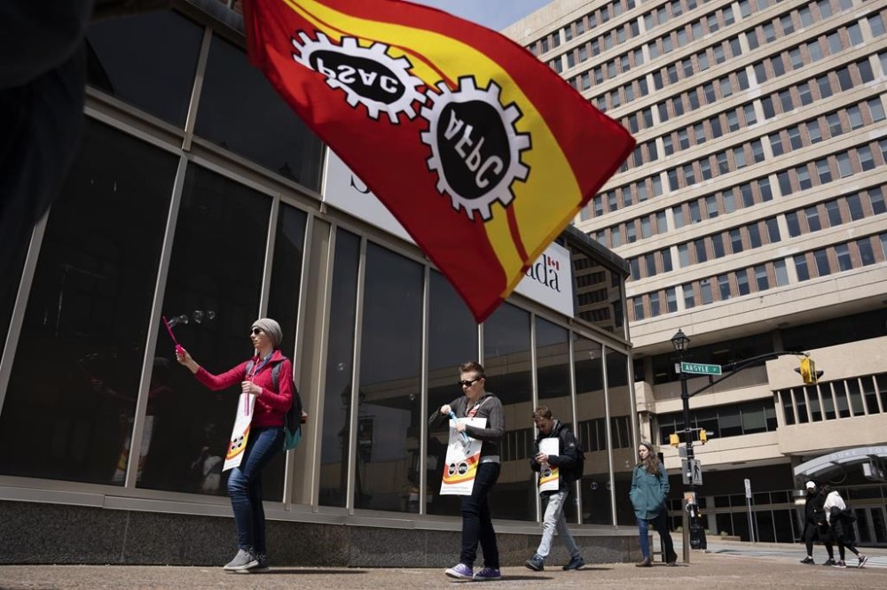 PSAC workers and supporters walk a picket line in Halifax on Monday, April 24, 2023. The Public Service Alliance of Canada says it's made some progress on wage demands and job security in negotiations with the federal government as thousands of federal workers remain on strike for the 12th straight day. THE CANADIAN PRESS/Darren Calabrese
