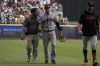 San Francisco Giants center fielder Mike Yastrzemski, center, walks with a trainer after an injury as manager Gabe Kapler walks alongside, right, during the eighth inning of a baseball game against the San Diego Padres, Sunday, April 30, 2023, in Mexico City. (AP Photo/Fernando Llano)