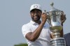 Tony Finau of the United States holds the championship trophy after his victory in the final round of the Mexico Open golf tournament in Puerto Vallarta, Mexico, Sunday, April 30, 2023. (AP Photo/Moises Castillo)