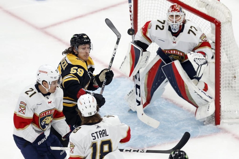 Boston Bruins' Tyler Bertuzzi (59) battles Florida Panthers' Nick Cousins (21) and Marc Staal (18) for the puck during the first period of Game 7 of an NHL hockey Stanley Cup first-round playoff series, Sunday, April 30, 2023, in Boston. (AP Photo/Michael Dwyer)