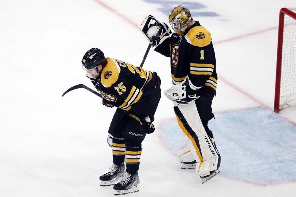 Boston Bruins' Brandon Carlo (25) and Jeremy Swayman (1) stand on the ice after losing to the Florida Panthers on a goal by Carter Verhaeghe in overtime during Game 7 of an NHL hockey Stanley Cup first-round playoff series, Sunday, April 30, 2023, in Boston. (AP Photo/Michael Dwyer)