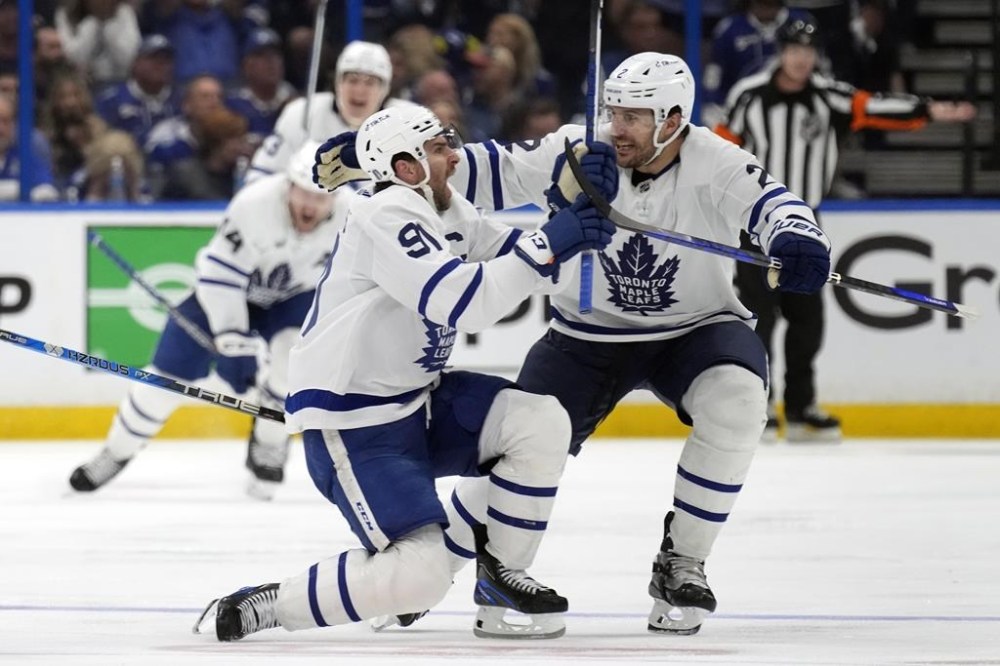 Toronto Maple Leafs center John Tavares (91) celebrates with defenseman Luke Schenn (2) after Tavares scored the game-winning against the Tampa Bay Lightning during overtime in Game 6 of an NHL hockey Stanley Cup first-round playoff series Saturday, April 29, 2023, in Tampa, Fla. (AP Photo/Chris O'Meara)