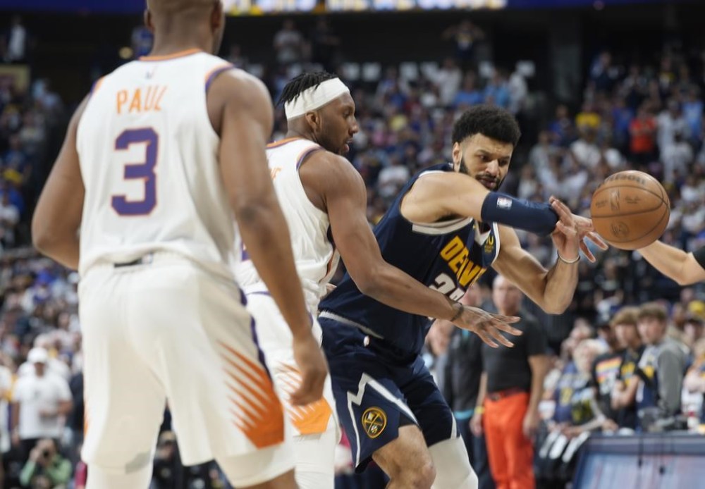 Denver Nuggets guard Jamal Murray, right, loses control of the ball as Phoenix Suns forward Josh Okogie, center, and guard Chris Paul defend in the first half of Game 2 of an NBA second-round playoff series Monday, May 1, 2023, in Denver. (AP Photo/David Zalubowski)