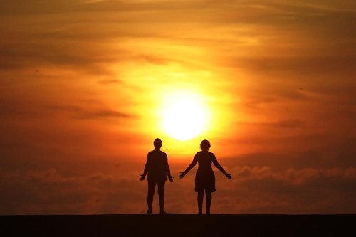 FILE - In this Sept. 19, 2020 file photo, a couple stands on a jetty as the sun rises over the Atlantic Ocean in Bal Harbour, Fla. Millions of Americans struggle with mental illnesses. One way to do so is by setting up a trust. An important question to ask is how a trust will affect their loved one’s eligibility for government benefits. Other factors to explore include the best trustees to appoint and whether their estate plan is clear and easy to follow. (AP Photo/Wilfredo Lee, File)