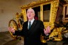 Britain's Speaker of the House of Commons Lindsay Hoyle stands next to the Speaker's State Coach as it returns to Westminster, ahead of the coronation of Britain's King Charles III, in London, Sunday, April 30, 2023. The gilded coach, which was last seen in the historic Westminster Hall in 2005, will be on display once again from 2 May to the Autumn, to commemorate the crowning of King Charles III. (AP Photo/Alberto Pezzali)