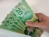 Canadian $20 bills are pictured in Toronto on September 9, 2022. Countries around the world whose currencies pay tribute to the late Queen Elizabeth II now have a new monarch — and a decision to make about whether the King has a place on their money. THE CANADIAN PRESS/Staff