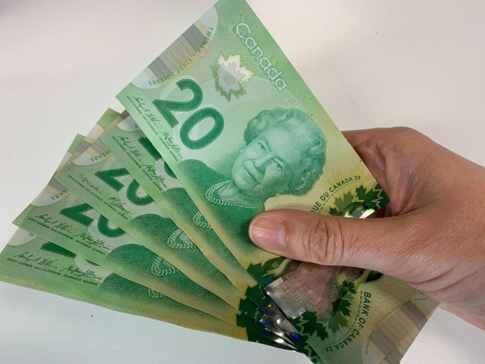 Canadian $20 bills are pictured in Toronto on September 9, 2022. Countries around the world whose currencies pay tribute to the late Queen Elizabeth II now have a new monarch — and a decision to make about whether the King has a place on their money. THE CANADIAN PRESS/Staff