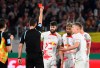 Referee Sven Jablonski shows the red card to Leipzig's Josko Gvardio, center, during the German Soccer Cup semifinal match between SC Freiburg and RB Leipzig in Freiburg, Germany, Tuesday, May 2, 2023. (Marijan Murat/dpa via AP)