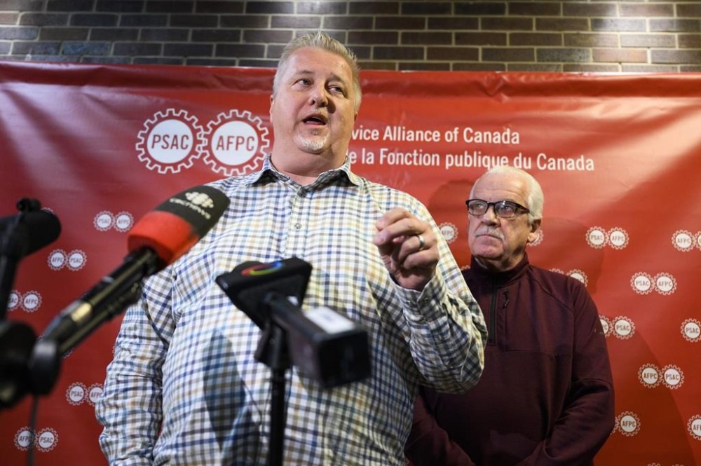 Marc Briere, National President of the Union of Taxation Employees, participates in a news conference as Chris Aylward, PSAC national President looks on, on the negotiations with Canada Revenue Agency, as PSAC-UTE members, who comprise a component of the Public Service Alliance of Canada (PSAC), remain on strike, in Ottawa, on Wednesday, May 3, 2023. THE CANADIAN PRESS/Justin Tang