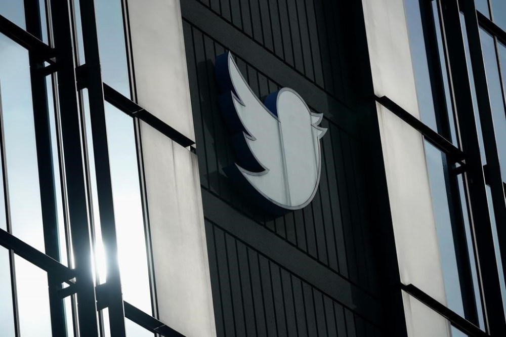 FILE - A Twitter logo hangs outside the company's offices in San Francisco, on Dec. 19, 2022. Elon Musk threatened to reassign NPR’s Twitter account to “another company,” according to the non-profit news organization, in an ongoing spat between Musk and media groups since his $44 billion acquisition of Twitter last year. (AP Photo/Jeff Chiu, File)
