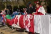 Bernadette Christie, right, and her husband Bruce Christie of Grand Prairie, Alta., hang their Canadian flags along the fence where she and her husband are camped out days before the official coronation of King Charles III near Buckingham Palace along the Mall in London on Wednesday, May 3, 2023. The Prime Minister's Office still has yet to announce which eminent Canadians will be invited to join him for the coronation of King Charles in just three days. THE CANADIAN PRESS/Nathan Denette
