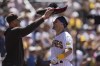 San Diego Padres' Manny Machado, left, puts a sombrero on Brett Sullivan, after Sullivan hit a two-run home run during the fourth inning of a baseball game against the Cincinnati Reds, Wednesday, May 3, 2023, in San Diego. (AP Photo/Gregory Bull)