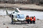 Rescuers carry the body of one of the two missing firefighters to a helicopter, Wednesday, May 3, 2023 in Baie-Saint-Paul, Que. The coroner's office has formally identified the two volunteer firefighters who were killed during the recent flooding in Quebec's Charlevoix region.THE CANADIAN PRESS/Jacques Boissinot