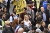 A protestor holds up a placard reading 