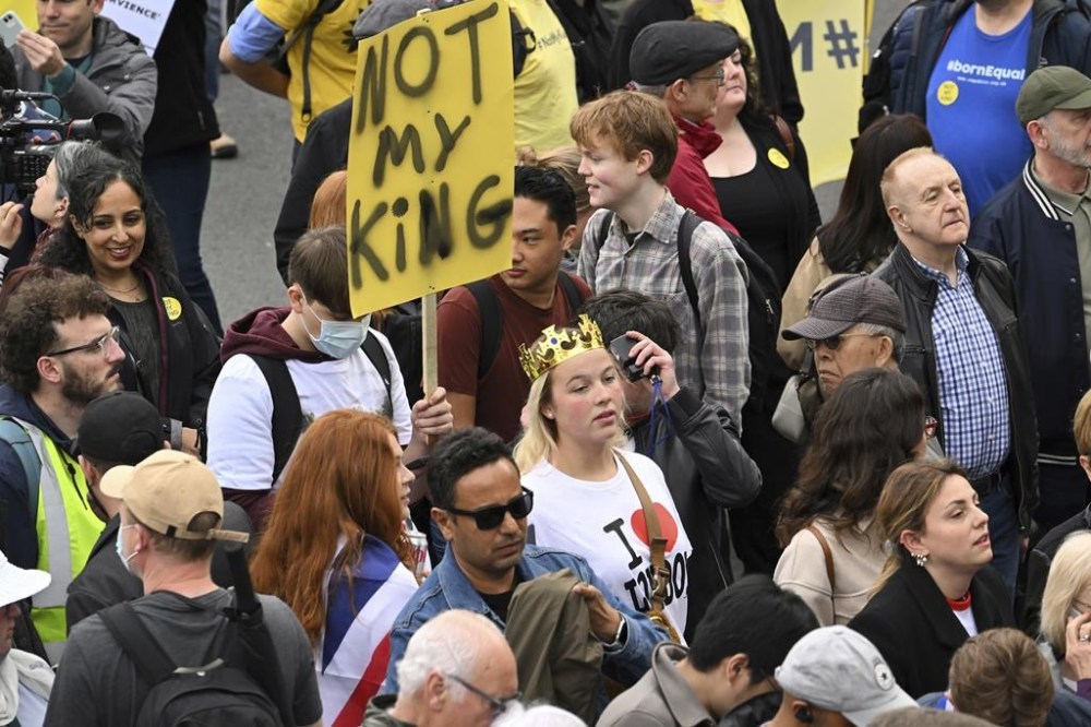 A protestor holds up a placard reading