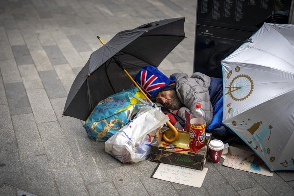 A man sleeps on the ground ahead of Britain's King Charles III coronation ceremony in London, Saturday, May 6, 2023. (AP Photo/Emilio Morenatti)