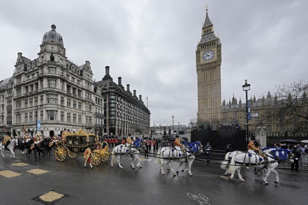 Britain's King Charles III and Camilla, the Queen Consort, ride in the Diamond Jubilee State Coach past the Palace of Westminster on the way to their coronation ceremony, in London Saturday, May 6, 2023. (AP Photo/Markus Schreiber)