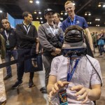 Lucas Anderson of Casey, Illinois tries on VR goggles for a flight simulator at the Berkshire Bazaar of Bargains at the CHI Health Center on Friday, May 5, 2023. (Chris Machian/Omaha World-Herald via AP)