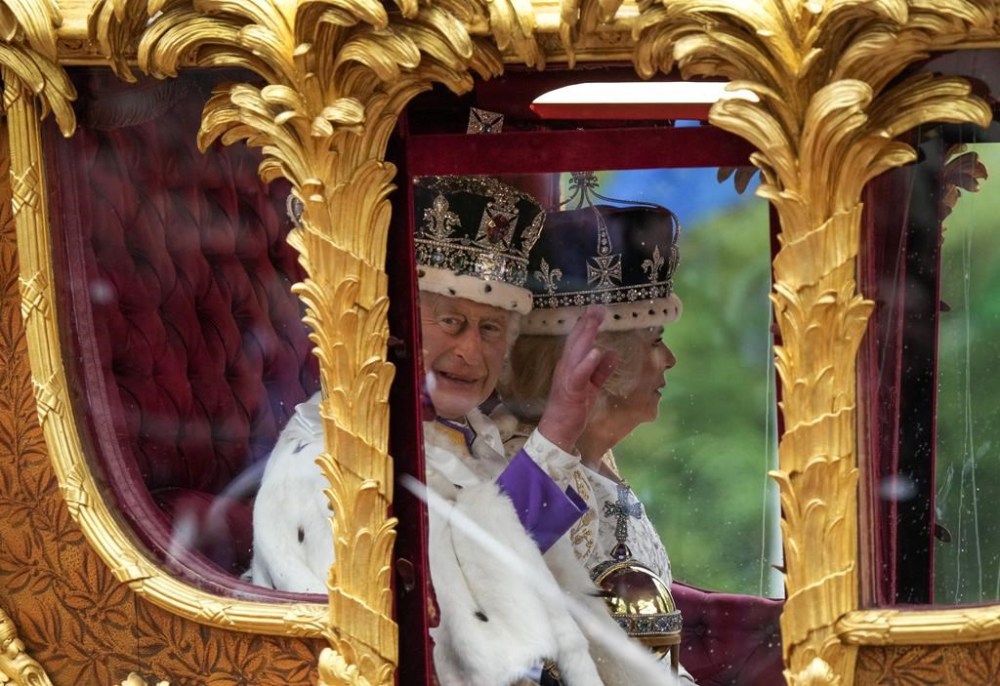 King Charles lll waves from the carriage beside Queen Camilla during the Royal Procession following the King's Coronation, in London on Saturday, May 6, 2023. THE CANADIAN PRESS/Nathan Denette