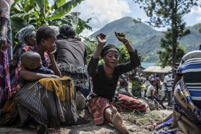 A woman reacts upon discovering that members of her family were killed, as volunteers nearby remove their bodies, in the village of Nyamukubi, South Kivu province, in Congo Saturday, May 6, 2023. The death toll from flash floods and landslides in eastern Congo has risen according to the governor and authorities in the country's South Kivu province. (AP Photo/Moses Sawasawa)