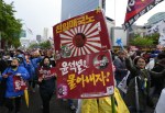 Protesters with an images of South Korean President Yoon Suk Yeol projected on an old imperial Japanese army flag march during a rally to denounce policies of the government on Japan in Seoul, South Korea, Saturday, May 6, 2023. Japanese Prime Minister Fumio Kishida is scheduled to arrive on Sunday to meet with Yoon for a two-day visit in Seoul. The signs read, 