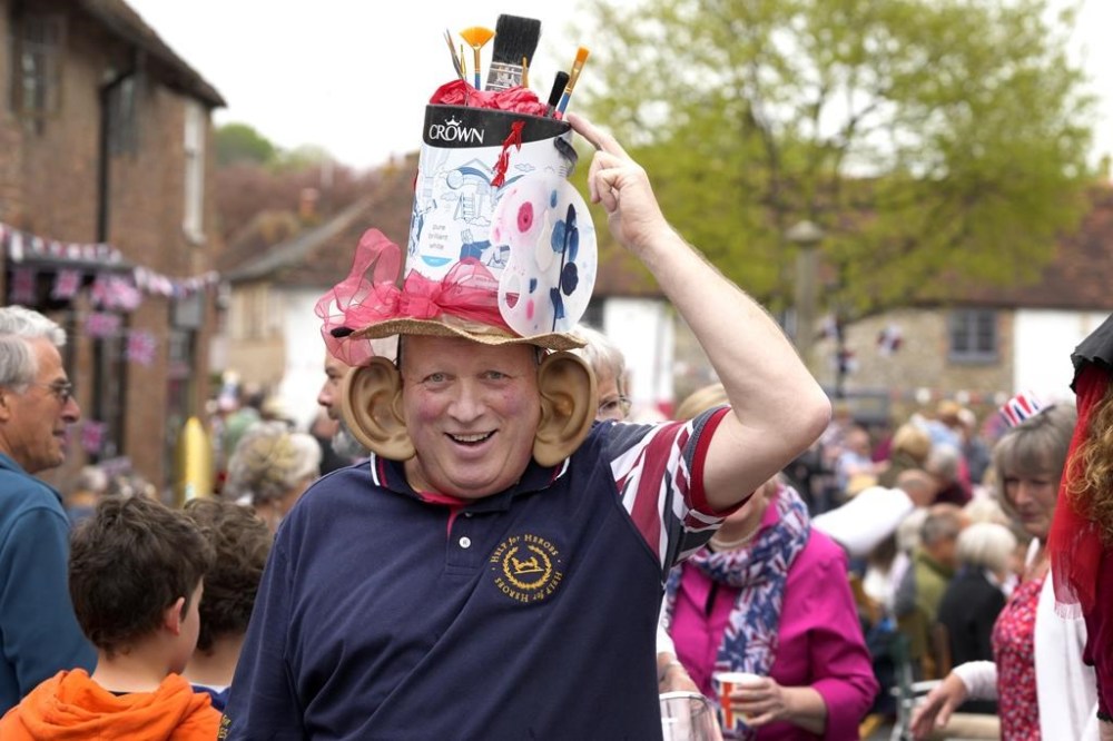 A man wears a crown at the Big Lunch celebration in Alfriston in East Sussex, England, Sunday, May 7, 2023. The Big Lunch is part of the weekend of celebrations for the Coronation of King Charles III. (AP Photo/Kirsty Wigglesworth)
