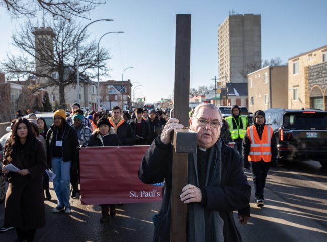 <p>JESSICA LEE / WINNIPEG FREE PRESS</p>
<p>Archbishop Richard Gagnon walks carrying a cross on Osborne St. on Friday for the Way of the Cross walk. Hundreds joined him in singing and reflecting while they walked.</p>
