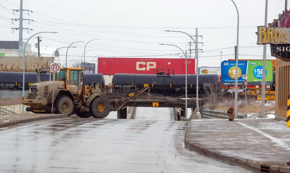 Roads will likely remain closed for the next few days as the Canadian Pacific Railway cleans up the site and the integrity of the bridge, which was built in 1912, is assessed. (Mike Deal / Winnipeg Free Press)