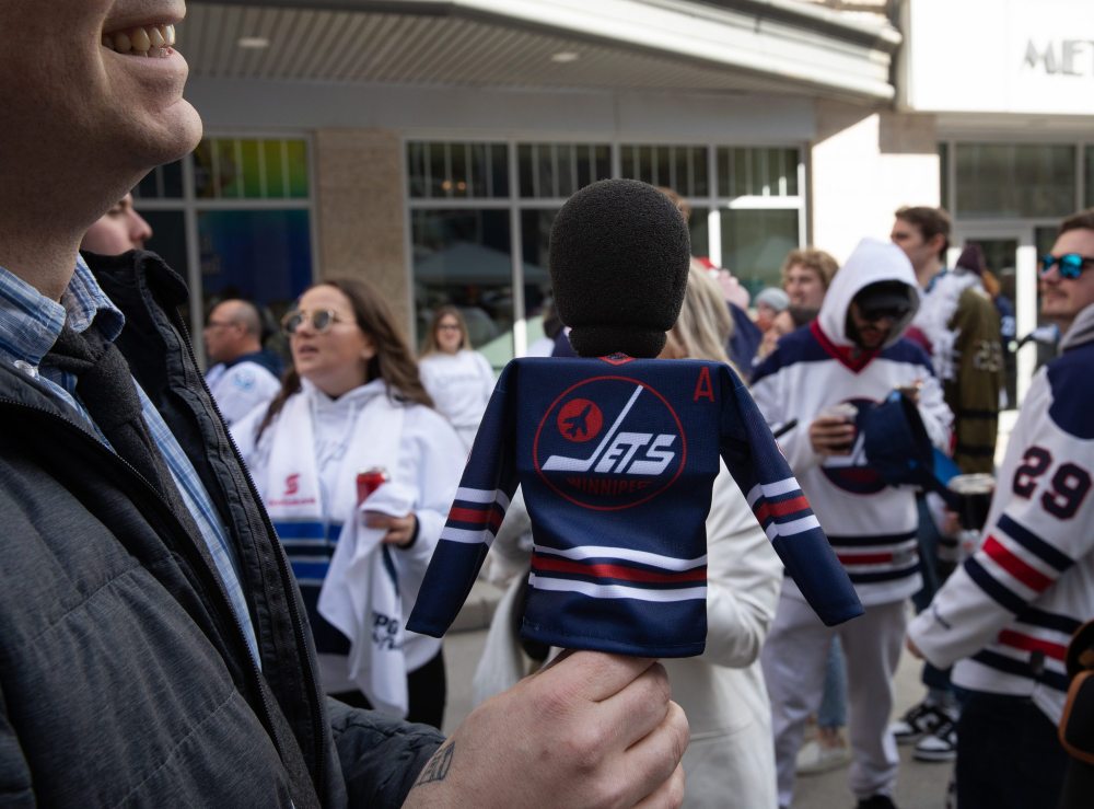 JESSICA LEE / WINNIPEG FREE PRESS
A reporter holds a microphone wearing a Winnipeg Jets jersey during a Whiteout party. Thousands of Winnipeg Jets fans gathered downtown beside Canada Life Centre April 22, 2023 to watch the Jets play against the Golden Knights.