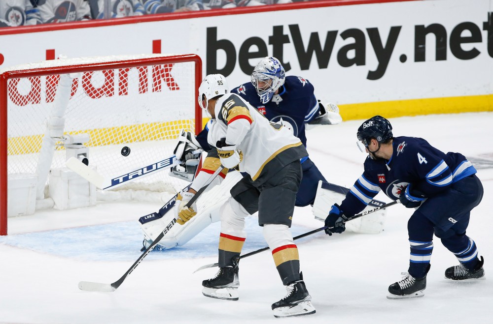 JOHN WOODS / THE CANADIAN PRESS
Vegas Golden KnightsÕ Keegan Kolesar (55) scores on Winnipeg Jets goaltender Connor Hellebuyck (37) as Neal Pionk (4) defends during the second period.