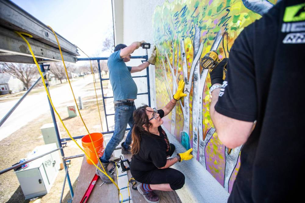 MIKAELA MACKENZIE / WINNIPEG FREE PRESS
Charlie Johnston (left), Jeannie White Bird, and Brad Lent install large mural on east side of Harrow United Church in Winnipeg on Wednesday, May 3, 2023. For Brenda Suderman story. Winnipeg Free Press 2023.